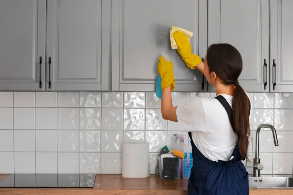 Wiping down Kitchen Cabinets during house cleaning in Cincinnati